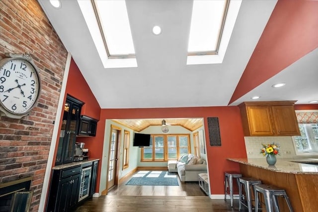 7 Scenic Dr, Wilbraham, MA 01095 - kitchen featuring a skylight, vaulted ceiling, beverage cooler, hardwood / wood-style floors, and light stone counters