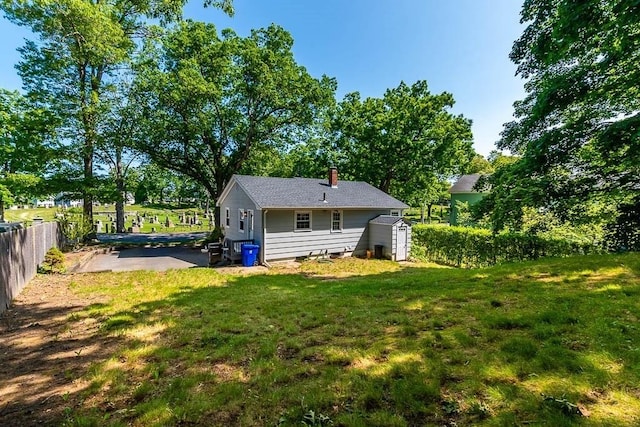 66 Barnum St, Taunton, MA 02780 - back of house with a storage unit, a chimney, and a patio area