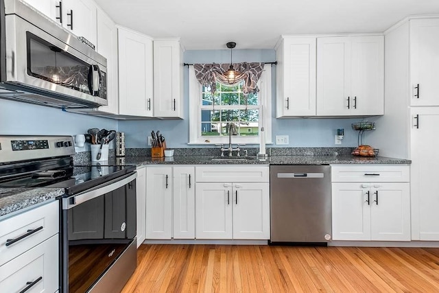 66 Barnum St, Taunton, MA 02780 - kitchen featuring appliances with stainless steel finishes, white cabinetry, dark stone counters, and light wood-type flooring