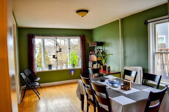 dining space featuring baseboards and hardwood / wood-style floors