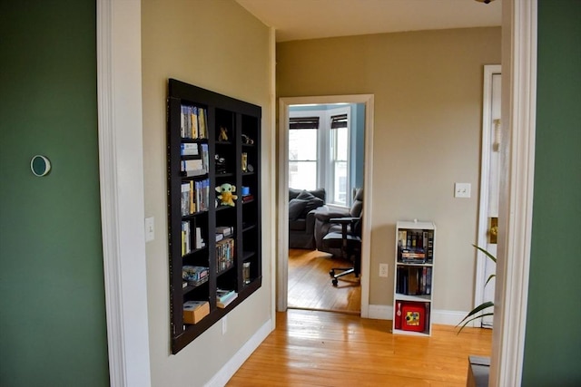 hallway featuring baseboards and wood finished floors
