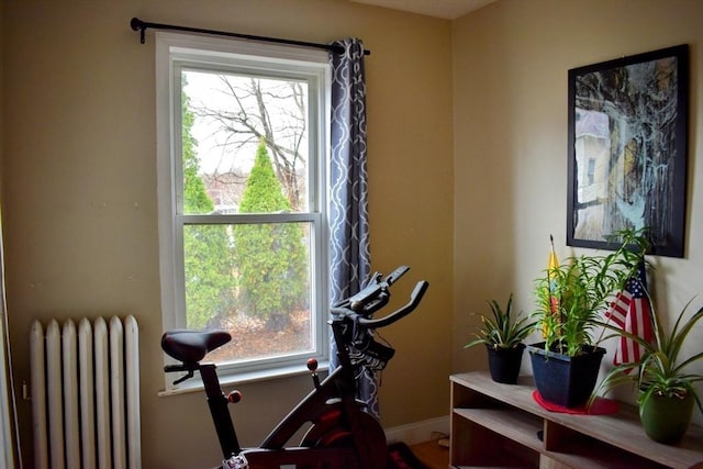 workout area featuring radiator heating unit and baseboards