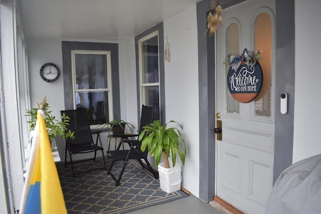 view of exterior entry with covered porch and stucco siding