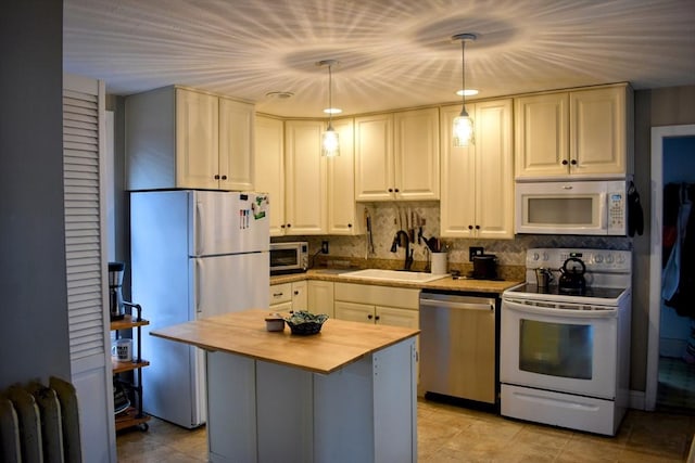 kitchen with butcher block counters, radiator, decorative backsplash, stainless steel appliances, and a sink