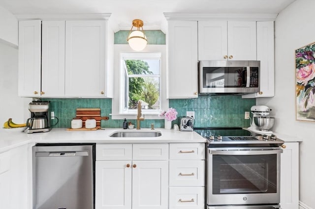 16 Desmond Ave, Manchester, MA 01944 - kitchen featuring stainless steel appliances, white cabinetry, backsplash, and light countertops