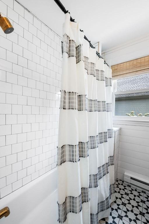 16 Desmond Ave, Manchester, MA 01944 - bathroom featuring shower / bath combo with shower curtain, a baseboard radiator, tile patterned floors, and tile walls