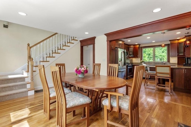 dining area with light wood-style flooring, stairs, and recessed lighting