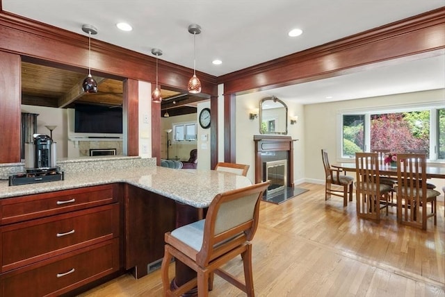 kitchen featuring a fireplace, light wood-style flooring, hanging light fixtures, recessed lighting, and beam ceiling
