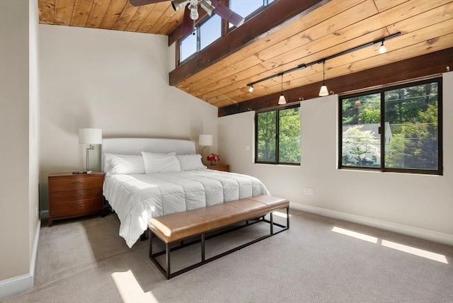 carpeted bedroom with rail lighting, baseboards, and wooden ceiling