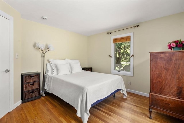 bedroom featuring wood finished floors and baseboards