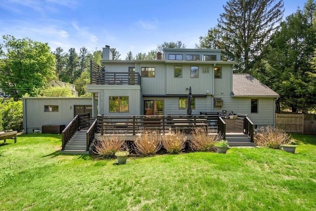back of house with a balcony, a chimney, and a wooden deck