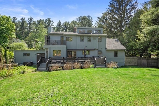 rear view of property with a balcony, a chimney, and a wooden deck