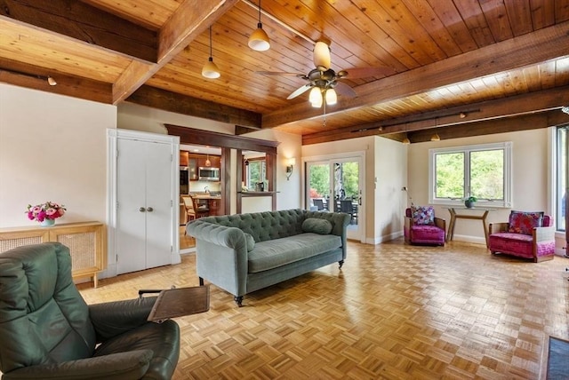 living area with wooden ceiling, baseboards, beamed ceiling, and ceiling fan