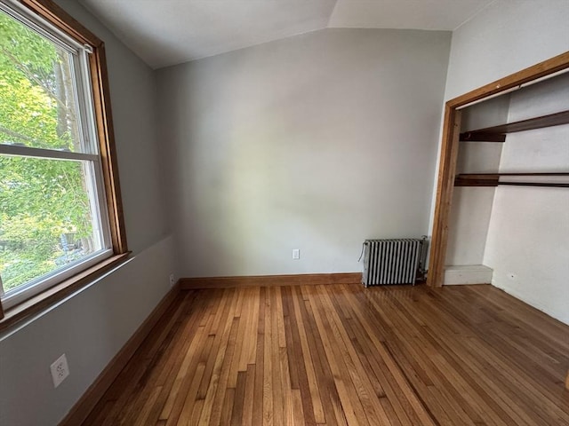 65 Cedar St, Weymouth, MA 02189 - unfurnished bedroom featuring radiator heating unit, multiple windows, wood-type flooring, vaulted ceiling, and a closet