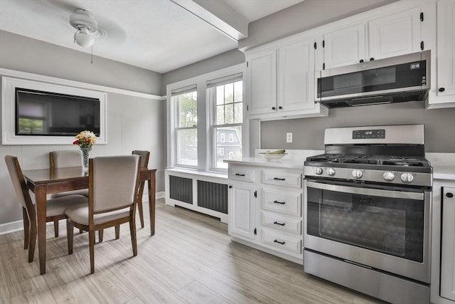10 Hemenway St, Methuen, MA 01844 - kitchen with appliances with stainless steel finishes, radiator heating unit, light countertops, and white cabinets
