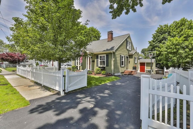 10 Hemenway St, Methuen, MA 01844 - view of front facade with a chimney, a gate, roof with shingles, and asphalt driveway