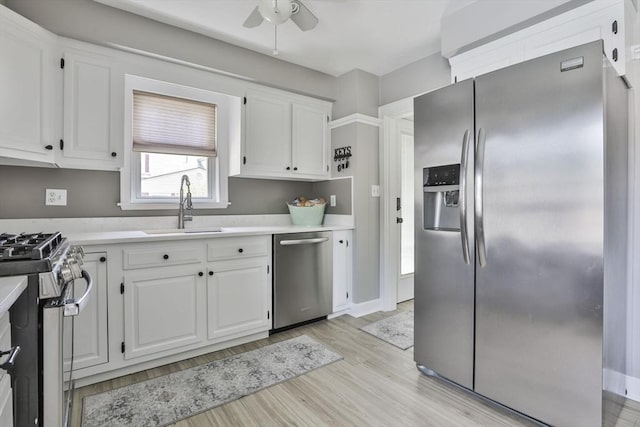 10 Hemenway St, Methuen, MA 01844 - kitchen with appliances with stainless steel finishes, a sink, white cabinets, light countertops, and light wood-type flooring