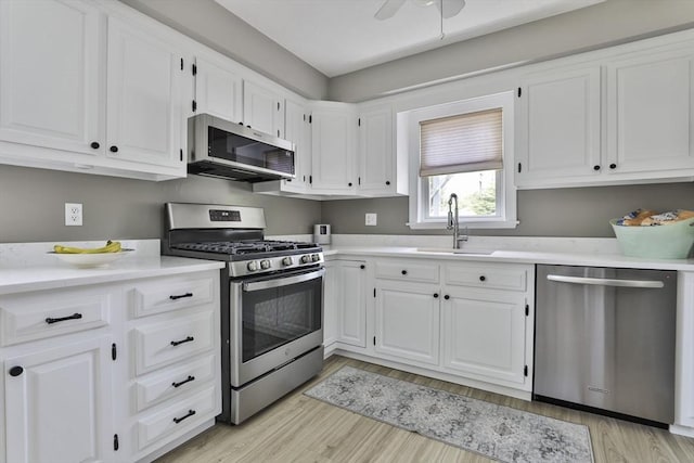 10 Hemenway St, Methuen, MA 01844 - kitchen featuring appliances with stainless steel finishes, a sink, white cabinets, light countertops, and light wood finished floors