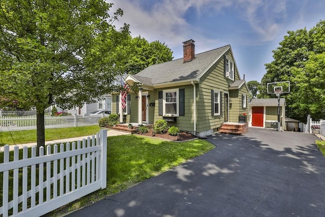 10 Hemenway St, Methuen, MA 01844 - view of front of property featuring a chimney, driveway, an outdoor structure, and roof with shingles