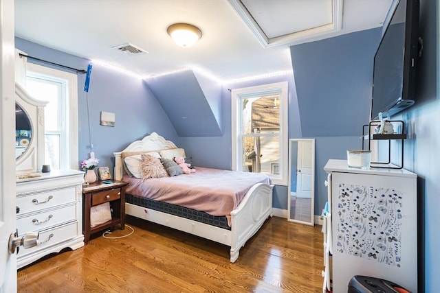 bedroom featuring lofted ceiling and hardwood / wood-style floors