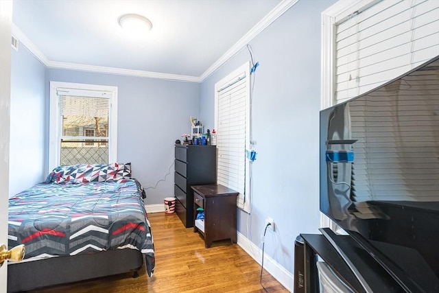 bedroom with ornamental molding and hardwood / wood-style floors