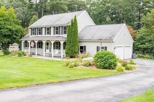 10 Tobin Dr, Dudley, MA 01571 - colonial-style house with driveway, a porch, a front yard, and an attached garage