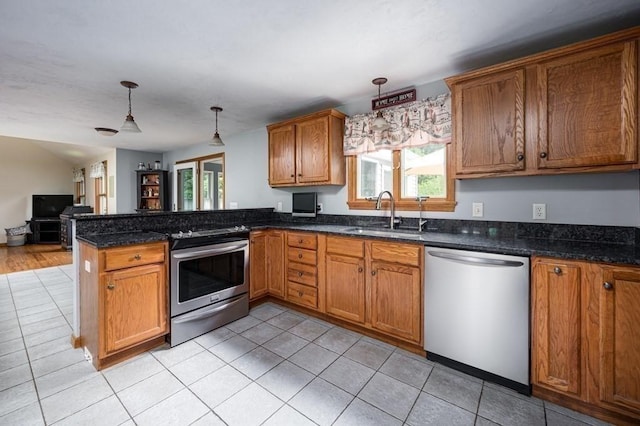10 Tobin Dr, Dudley, MA 01571 - kitchen with stainless steel appliances, a peninsula, open floor plan, brown cabinetry, and light tile patterned floors
