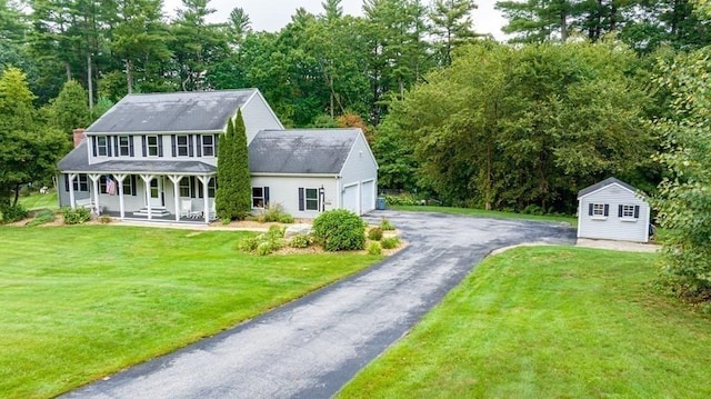 10 Tobin Dr, Dudley, MA 01571 - colonial home featuring covered porch, an attached garage, a front yard, asphalt driveway, and a shed