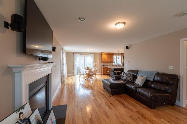 225 Salem Rd, Dracut, MA 01826 - living room featuring light wood finished floors, a fireplace with flush hearth, and baseboards