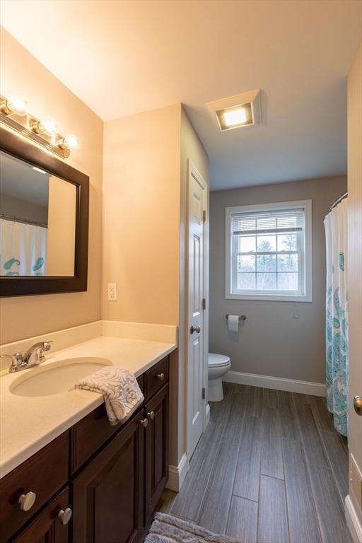 225 Salem Rd, Dracut, MA 01826 - bathroom featuring vanity, toilet, wood finished floors, and baseboards