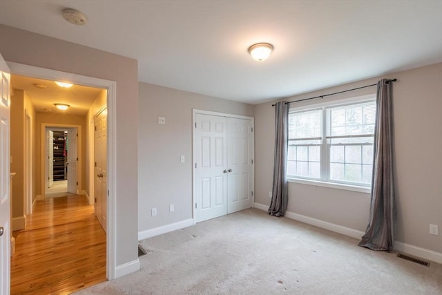 225 Salem Rd, Dracut, MA 01826 - unfurnished bedroom with baseboards, a closet, and light carpet