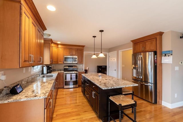 225 Salem Rd, Dracut, MA 01826 - kitchen with stainless steel appliances, a sink, a kitchen island, light wood finished floors, and brown cabinets