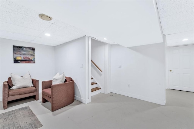 sitting room with stairway, finished concrete flooring, baseboards, and recessed lighting