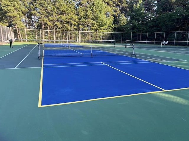 view of tennis court featuring fence