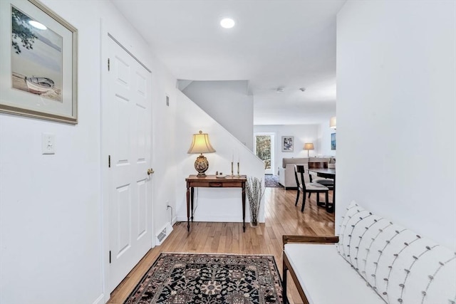 hallway featuring light wood-style floors, recessed lighting, and baseboards