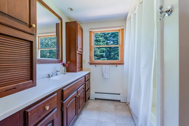 bathroom with a baseboard heating unit, tile patterned flooring, a wealth of natural light, and vanity