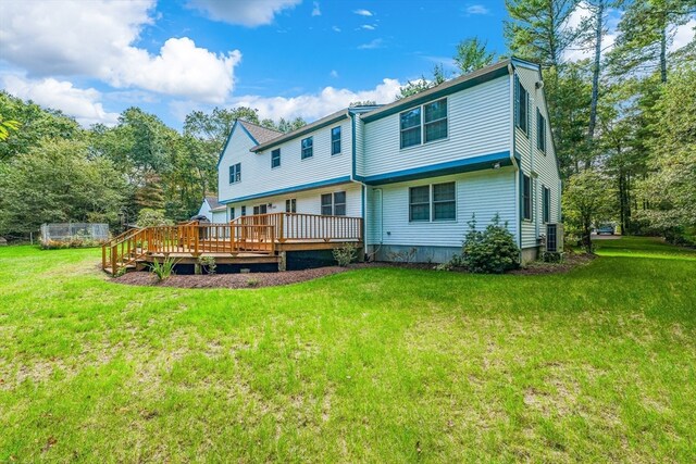 back of house featuring a lawn, a wooden deck, and central AC