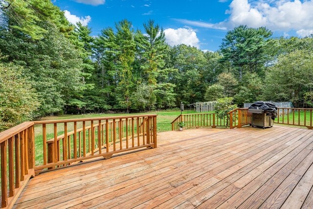 wooden terrace featuring a lawn