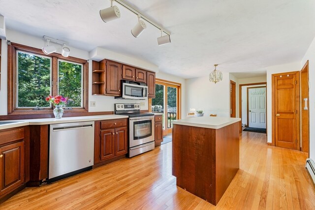 kitchen with stainless steel appliances, plenty of natural light, a kitchen island, and light wood-type flooring