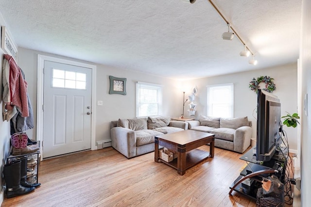 719 College Hwy, Southwick, MA 01077 - living room featuring a baseboard radiator, light wood-style floors, a textured ceiling, and rail lighting