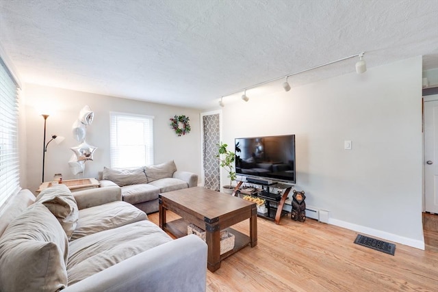 719 College Hwy, Southwick, MA 01077 - living room with rail lighting, light wood-style flooring, a textured ceiling, and baseboards