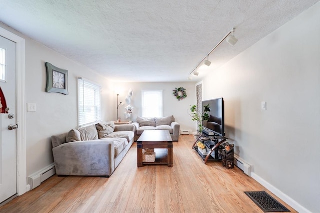 719 College Hwy, Southwick, MA 01077 - living area featuring baseboard heating, track lighting, wood finished floors, and a textured ceiling