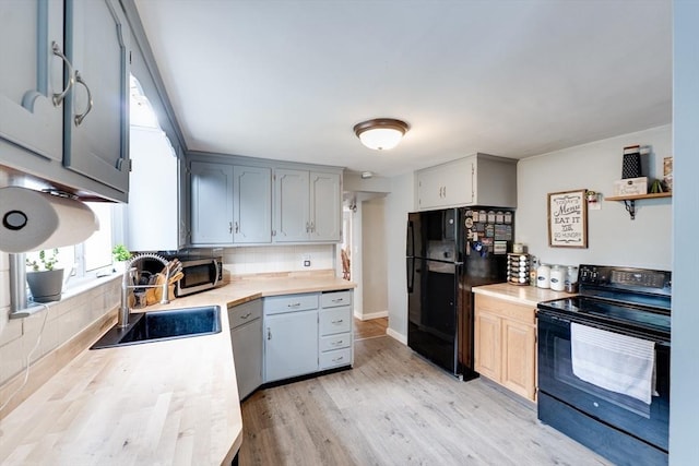 719 College Hwy, Southwick, MA 01077 - kitchen with black appliances, a sink, light countertops, light wood-type flooring, and backsplash