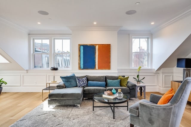 living room featuring a healthy amount of sunlight, ornamental molding, and light wood-type flooring