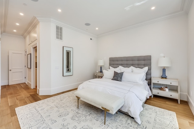 bedroom featuring ornamental molding and light hardwood / wood-style flooring