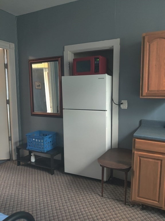 kitchen with white refrigerator and carpet