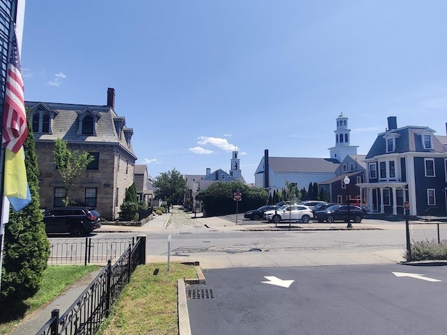 view of road with sidewalks, a residential view, and traffic signs