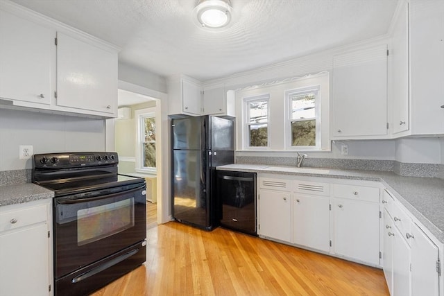 kitchen featuring white cabinets, sink, light hardwood / wood-style flooring, and black appliances