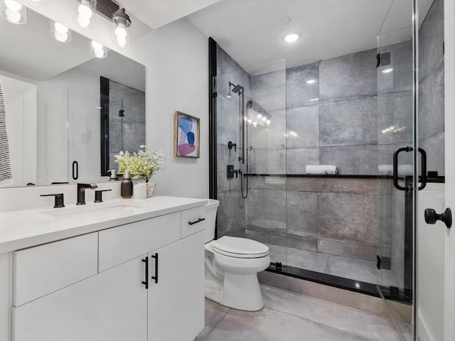 bathroom featuring vanity, toilet, and an enclosed shower