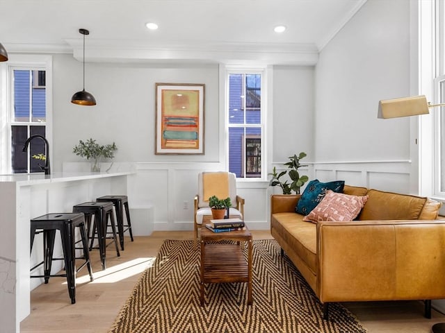 sitting room featuring light hardwood / wood-style floors, sink, and crown molding